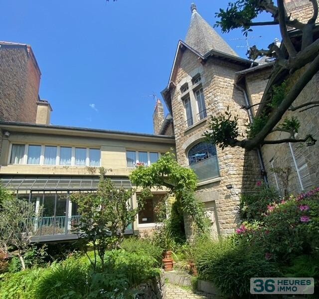 Maison de ville avec garage, nichée au fond d'un jardin ensoleillé.