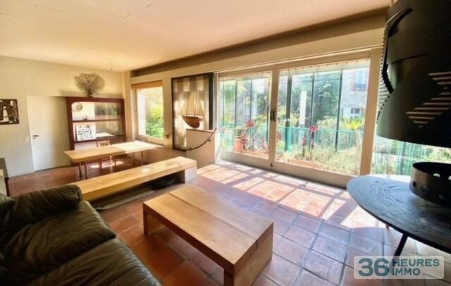 Maison de ville avec garage, nichée au fond d'un jardin ensoleillé.