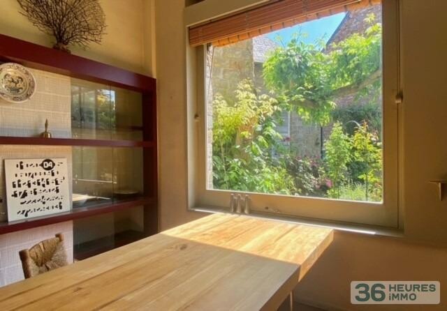 Maison de ville avec garage, nichée au fond d'un jardin ensoleillé.