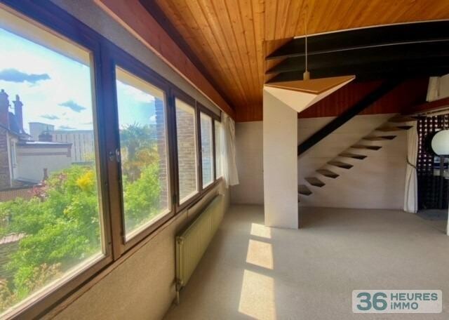 Maison de ville avec garage, nichée au fond d'un jardin ensoleillé.